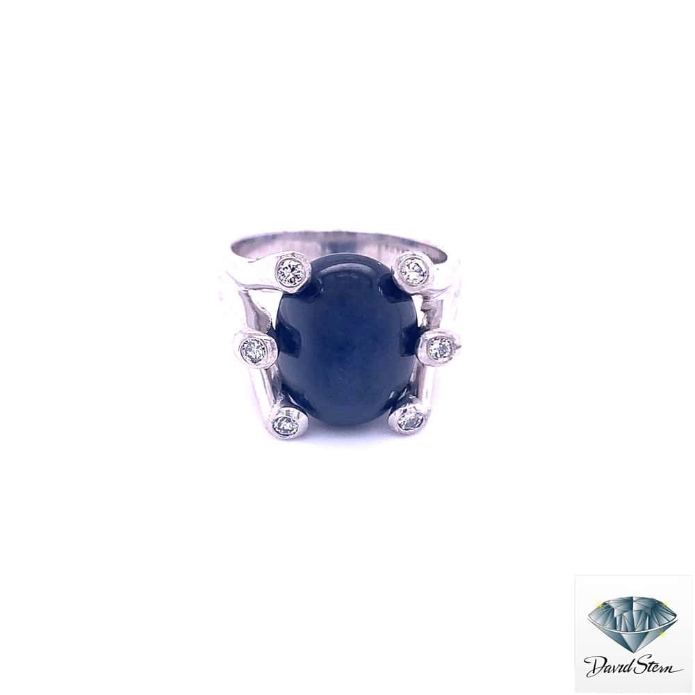 Oval black gemstone ring with diamonds set in a silver band, showcasing elegant jewelry craftsmanship.