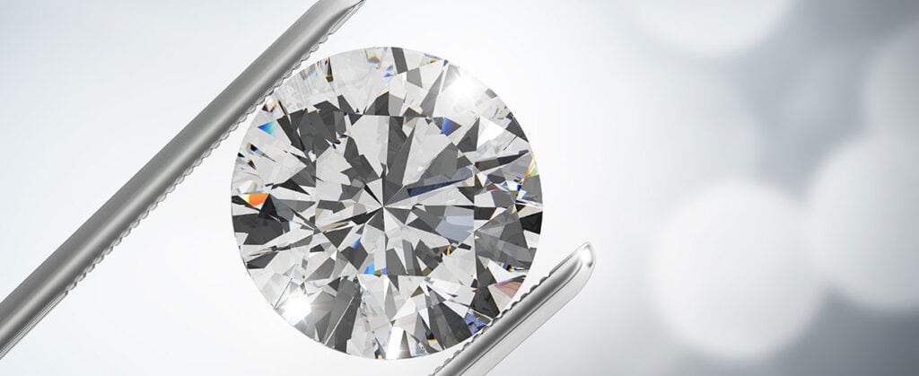 Bright round-cut diamond held with tweezers, showcasing high-quality jewelry and engagement rings at david stern jewelers.