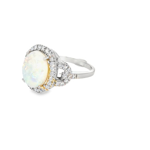 Side view of the white opal ring, showing the domed cabochon, the diamond halo and the scrolled gallery