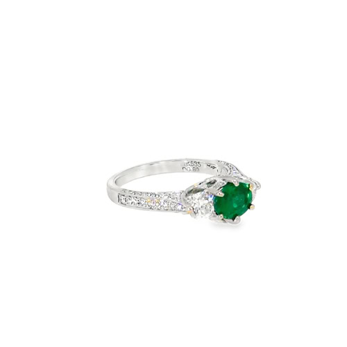 Side view of the oval emerald ring, showing the raised three stone setting and the diamonds down the shoulder