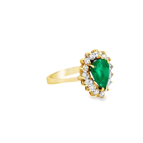 The pear emerald and diamond ring from the other side, showing the prongs holding the halo above the shank