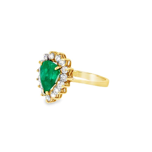 Side view of the pear emerald ring, showing the raised halo setting and the plain tapered yellow gold band
