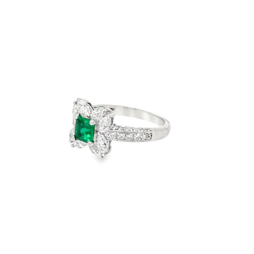 Side view of the emerald floral ring, showing the raised petal setting and the pave diamonds along the band