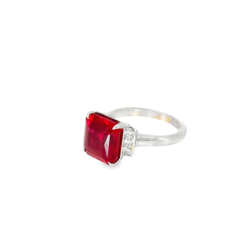 Side view of the lab grown ruby solitaire ring, showing the four prongs and the stepped diamond shoulders