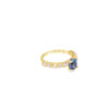 Side view of the oval tanzanite ring showing the four-prong center and prong-set diamonds along the band
