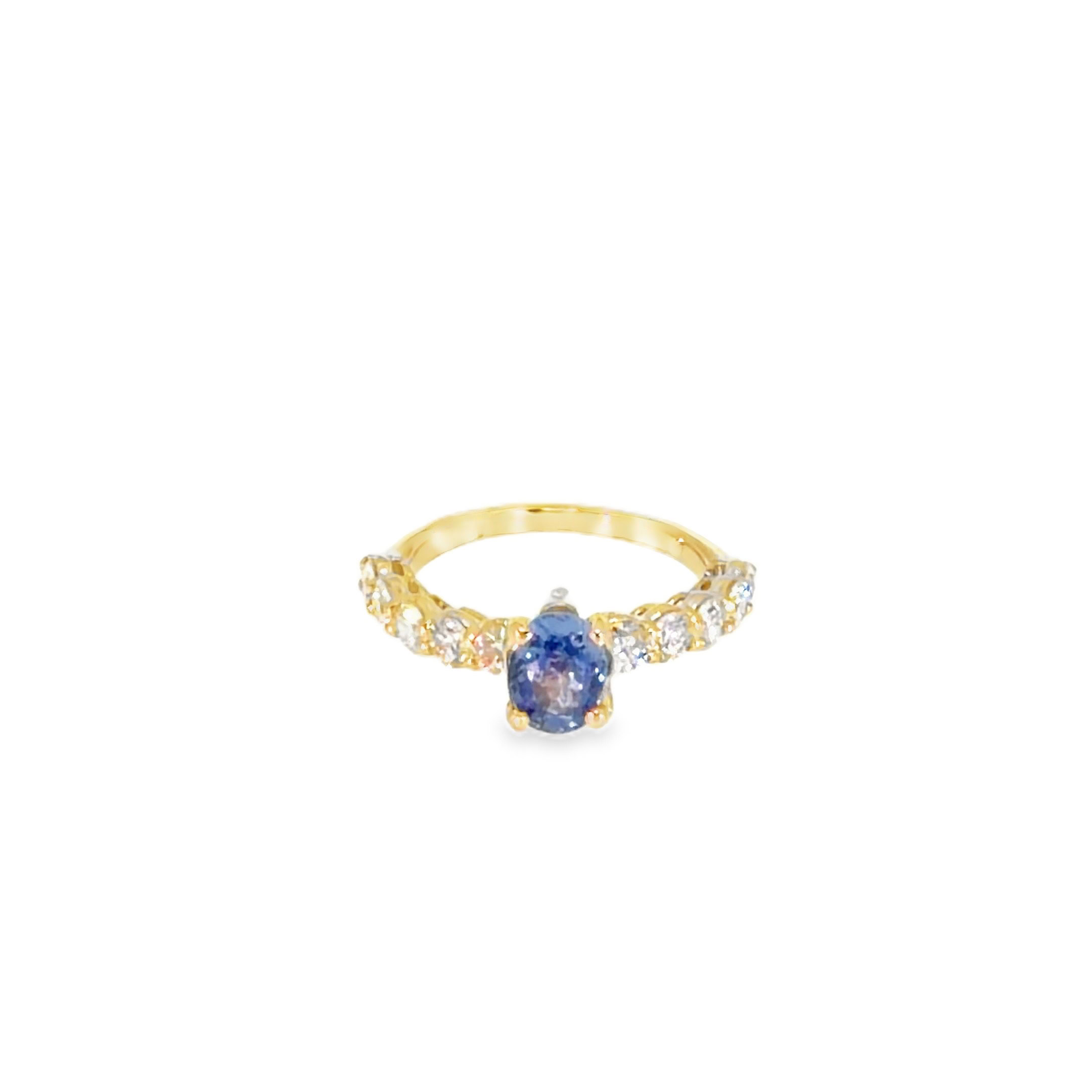 Tanzanite and diamond ring: 0.55 ct oval tanzanite in four prongs with round diamonds down an 18kt yellow gold band