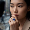 Styled image of an oval sapphire and diamond ring worn on the hand