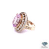 Large morganite ring seen from the left, showing the collar-set inner halo and diamond shoulders in yellow gold