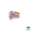 Two tone engagement ring set seen from the left: pear halo in white gold with a yellow gold diamond ring enhancer