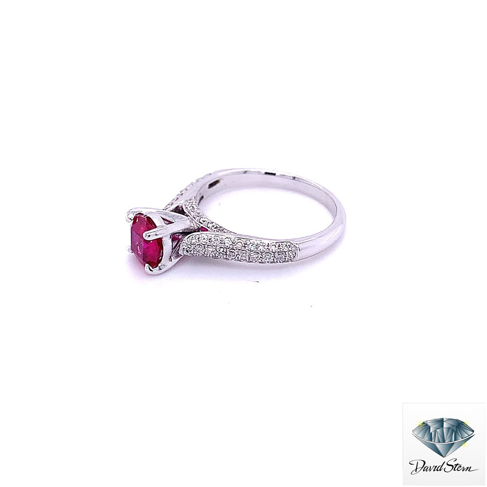 White gold ruby ring seen from the left: round ruby in four prongs with pave diamond shoulders