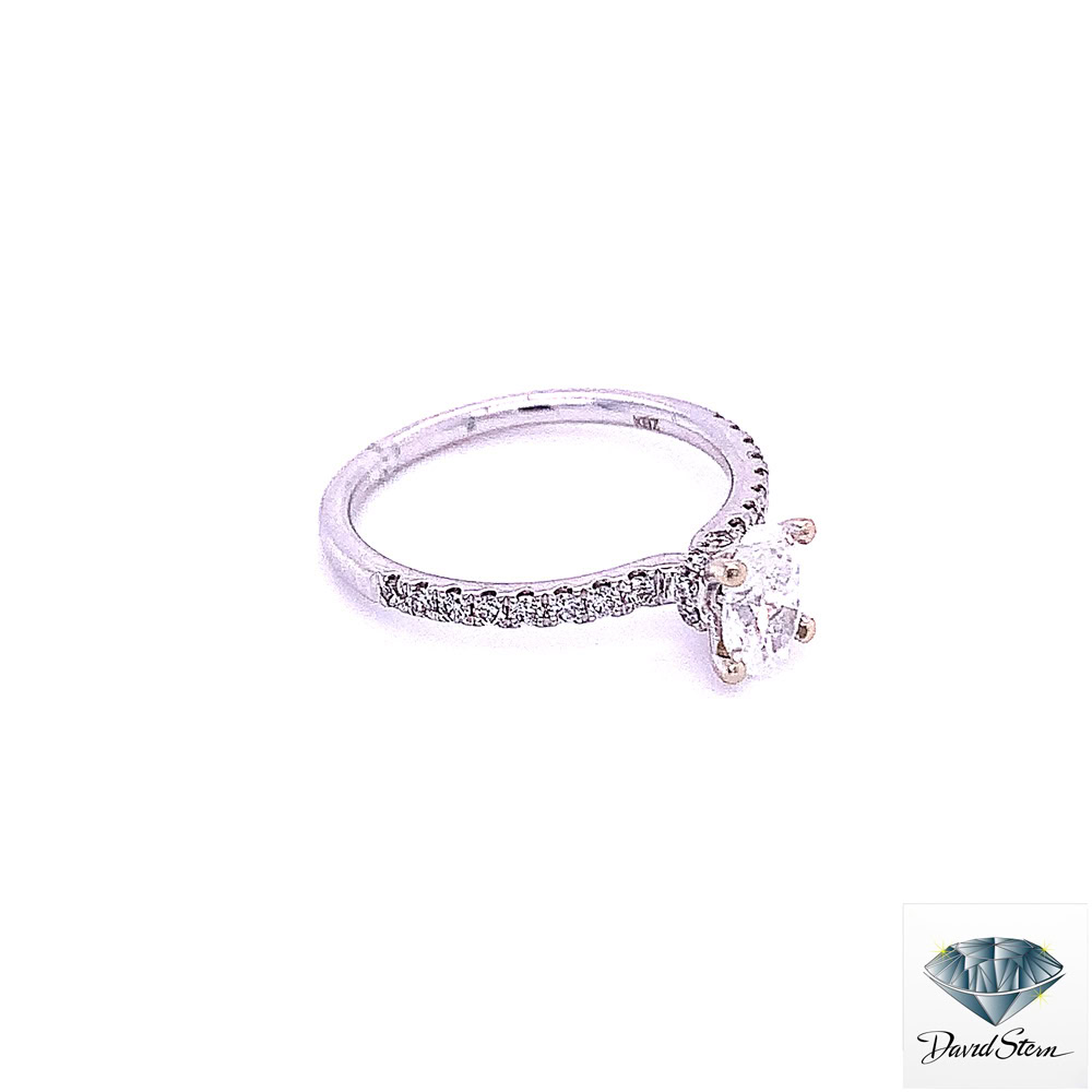 White gold oval engagement ring seen from the right, showing the slim band and single row of diamonds