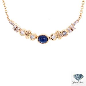 Cabochon sapphire necklace: oval cabochon sapphire between bezel-set diamonds and gold stations on a 14kt yellow gold chain