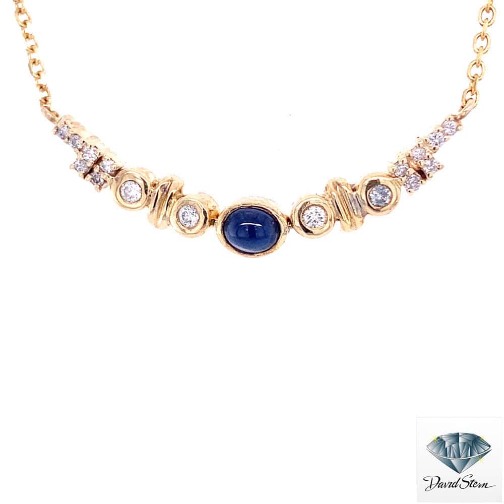 Cabochon sapphire necklace: oval cabochon sapphire between bezel-set diamonds and gold stations on a 14kt yellow gold chain