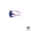 Side view of the sapphire cabochon ring showing the curved diamond-tipped arms and split shank