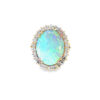 Two tone opal ring: a 4.00 ct oval opal cabochon with blue-green play-of-color in a white gold diamond halo on a yellow gold band