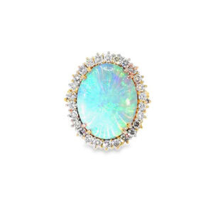Two tone opal ring: a 4.00 ct oval opal cabochon with blue-green play-of-color in a white gold diamond halo on a yellow gold band