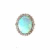 Two tone opal ring: a 4.00 ct oval opal cabochon with blue-green play-of-color in a white gold diamond halo on a yellow gold band