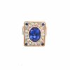 Tanzanite couture ring: a 6.38 ct oval tanzanite bezel set in rose gold inside a rectangular diamond and sapphire plaque, on an 18kt white, rose and yellow gold band