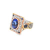 Side view of the tanzanite couture ring showing the filigree shoulders, the bezel-set blue sapphire accent and the tri-gold band