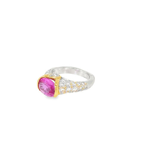 Side view of the east west pink ruby ring showing the yellow gold bezel, the pear shaped diamond shoulders and the pave band