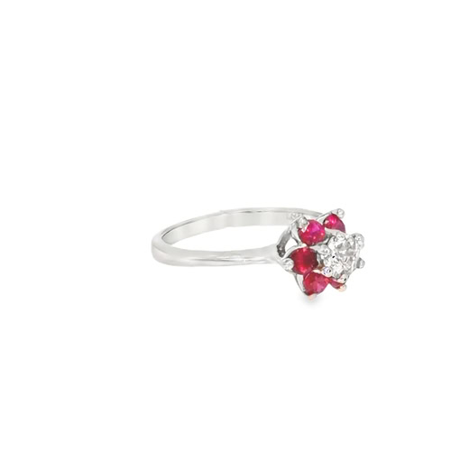 Angled view of the ruby flower ring, showing the raised cluster setting and the tapered white gold shank