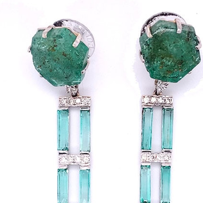 Sapphire and emerald earrings detail: sliced rough emerald tops above a ladder of emerald baguettes and diamond bars