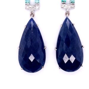 Pear sapphire earrings detail: faceted pear-shaped blue sapphire drops in claw settings, 18kt white gold