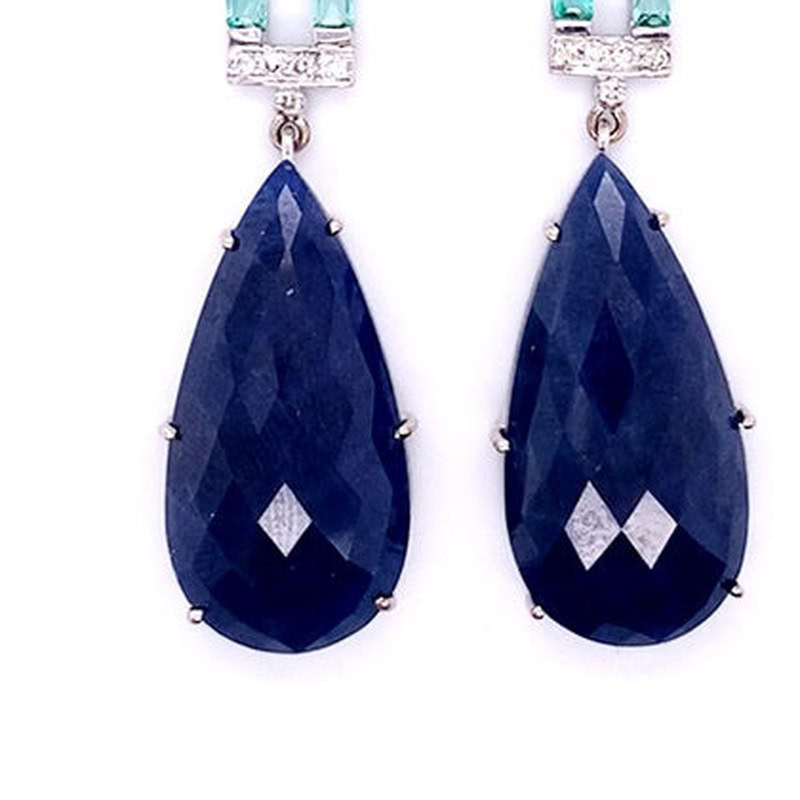 Pear sapphire earrings detail: faceted pear-shaped blue sapphire drops in claw settings, 18kt white gold