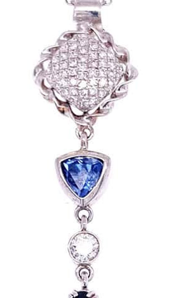 Pave diamond pendant detail: cushion-shaped pave diamond cluster in a rope frame above a bezel-set trillion tanzanite