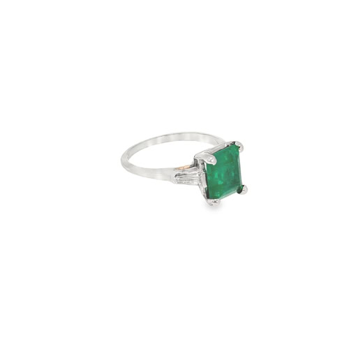 The three stone emerald ring from another angle, showing the tapered baguette diamonds beside the square emerald