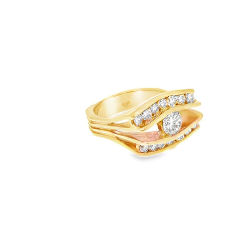 The wide band engagement ring from the opposite angle, showing the sweep of the channel-set diamonds around the centre stone